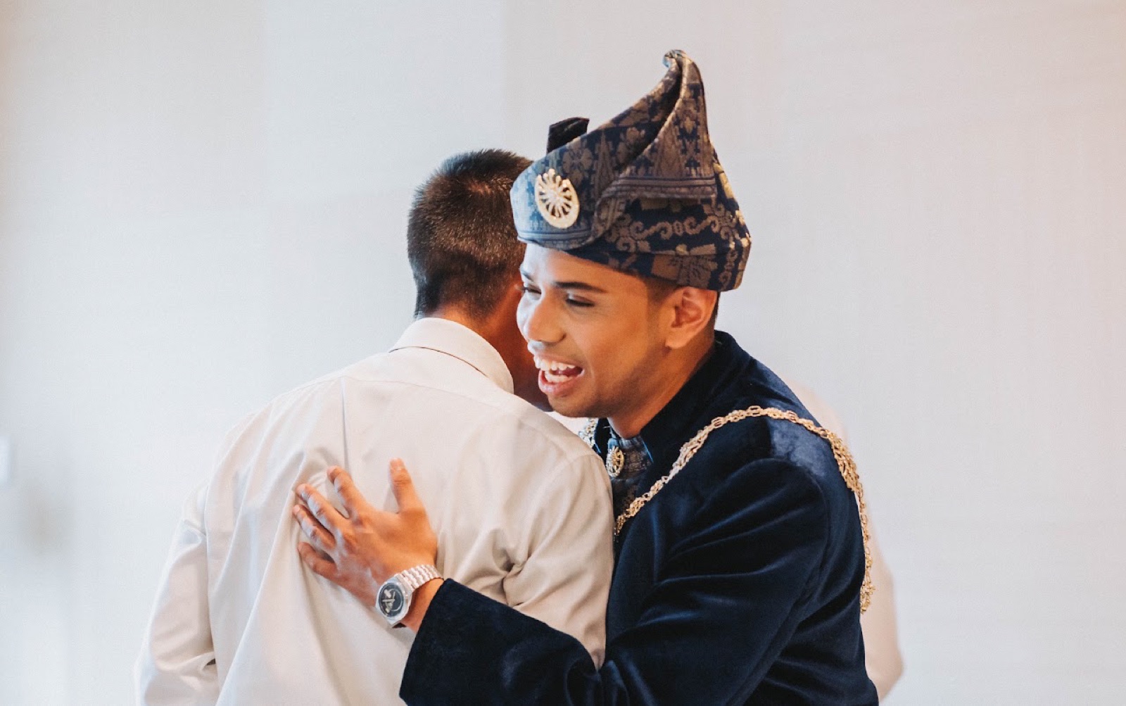 Groom embracing a guest at a Malay wedding